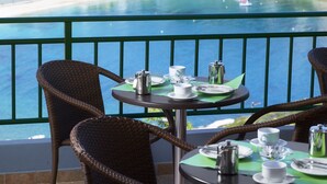 A table set for two with a view of a coastal town.