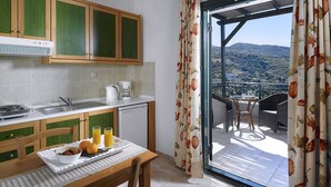 A kitchen with a dining area, a coffee maker, and a table with breakfast items.