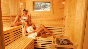 A wooden sauna with benches and a window.
