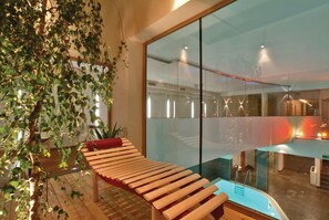 Un intérieur moderne avec un banc en bois, une cloison en verre et une vue sur l’extérieur.