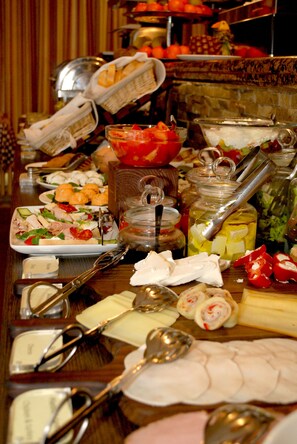A buffet table with various food items and utensils.
