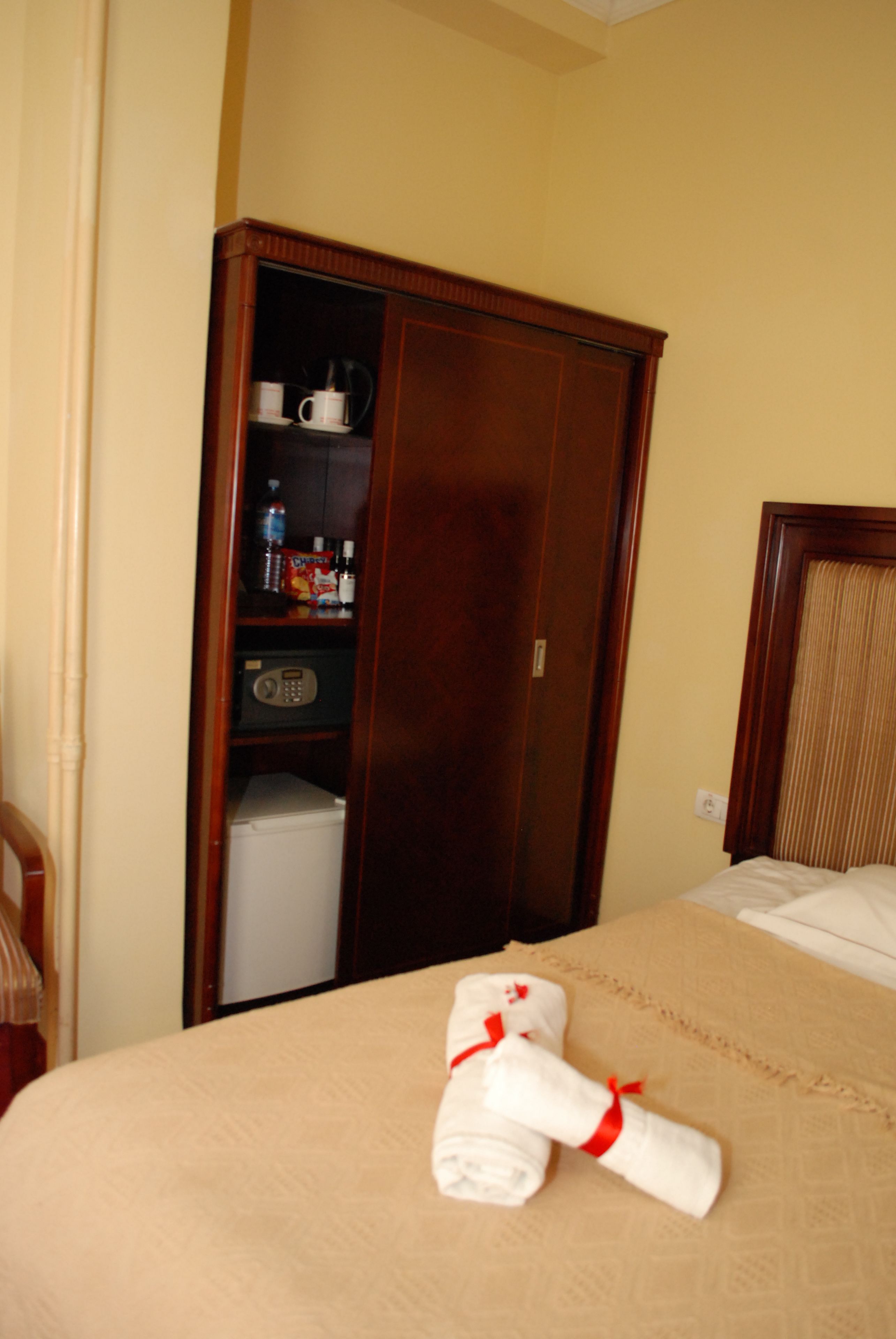 Una habitación de hotel con cama, armario y minibar.