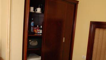 Una habitación de hotel con cama, armario y minibar.