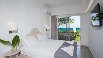 Ein Schlafzimmer mit zwei Betten, einem Fernseher und Meerblick.