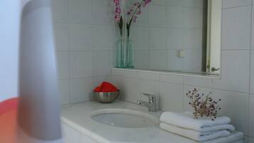 A bathroom with a sink, mirror, and towel rack.