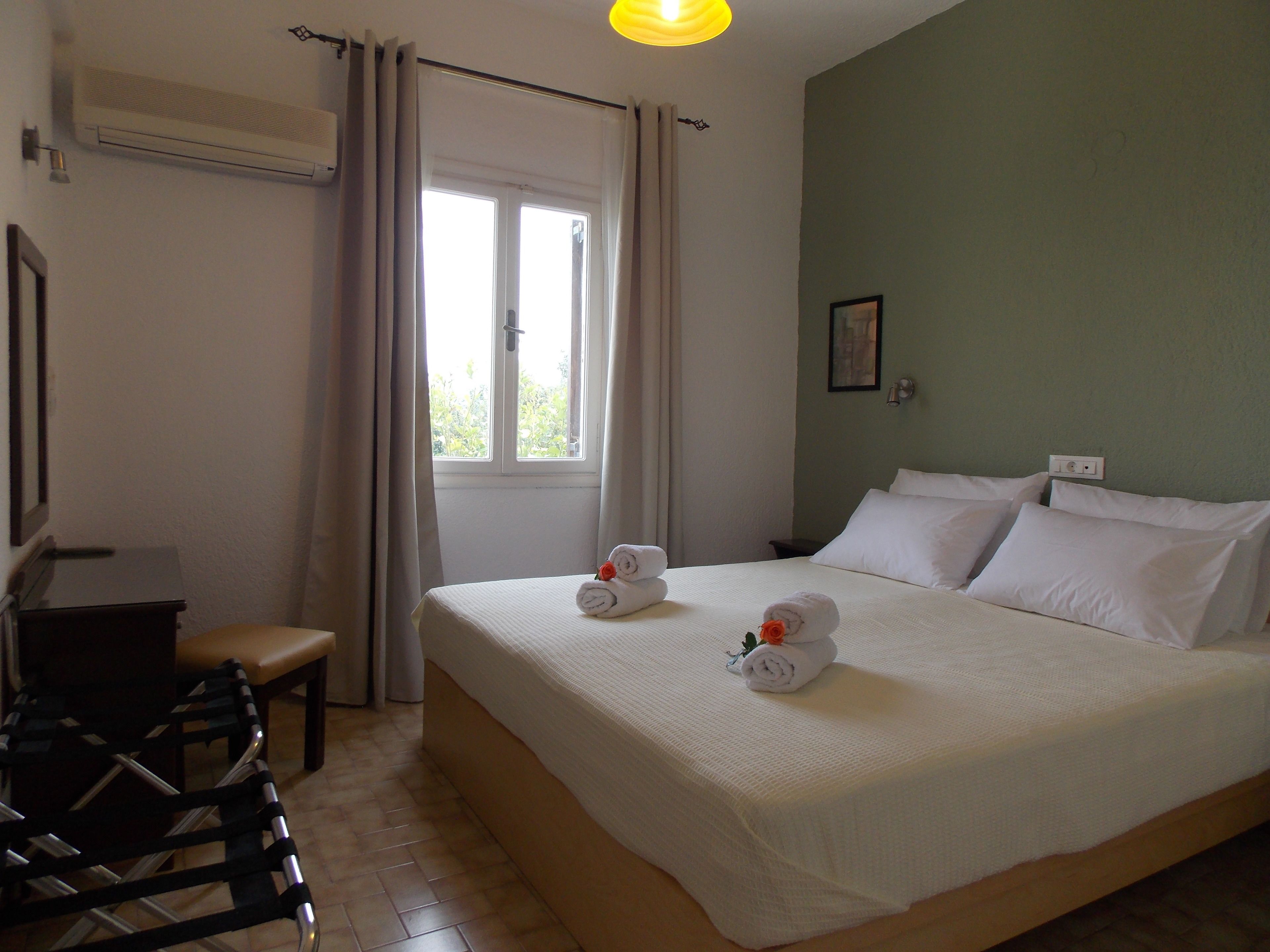 A hotel room with a bed, a desk, and a chair.