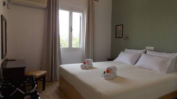 A hotel room with a bed, a desk, and a chair.