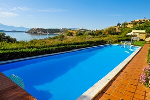Una piscina al aire libre de temporada, sombrillas