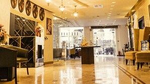 A spacious lobby with a curved ceiling, chandeliers, a reception desk, and seating areas. - Torino Amman Hotel (Amman)