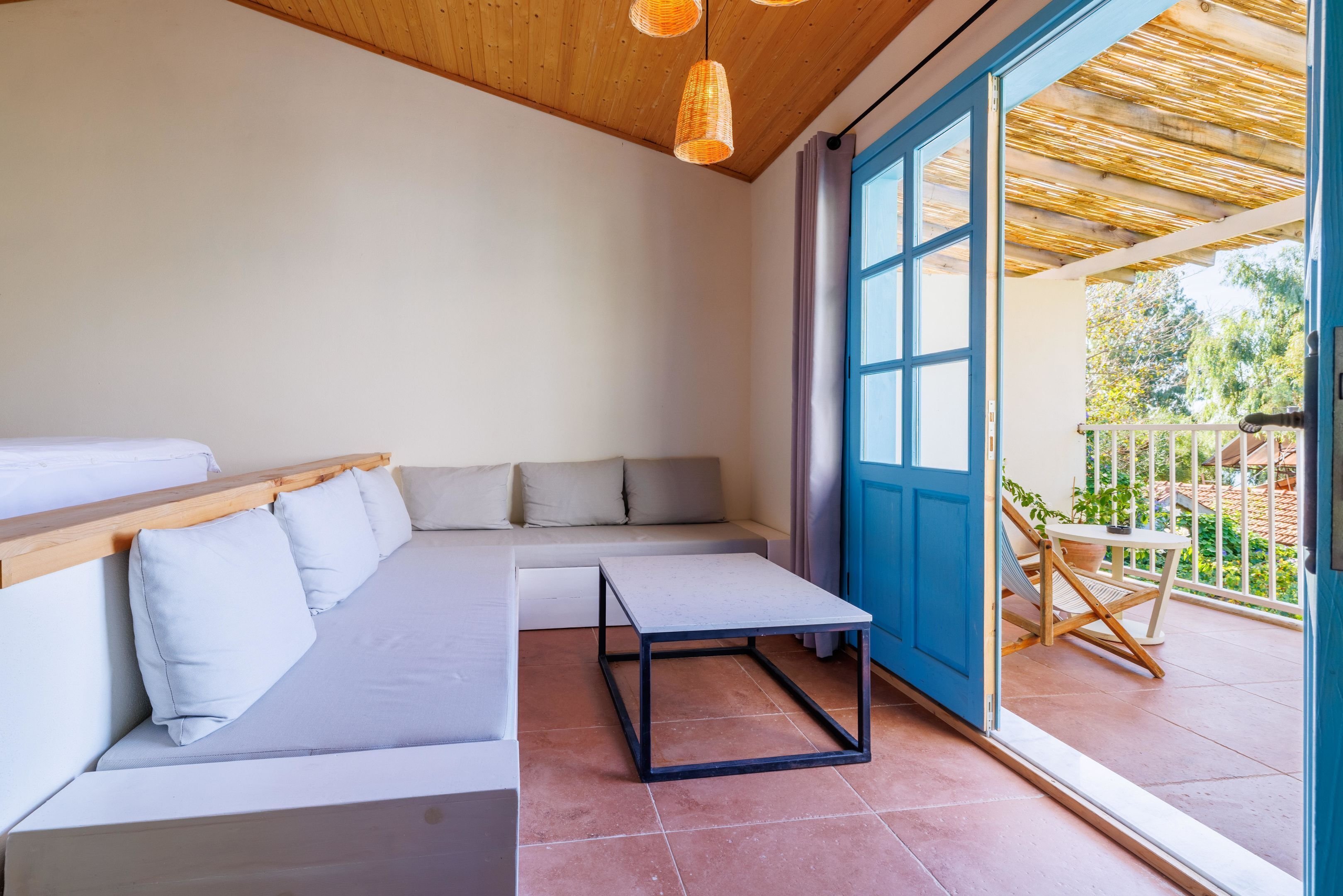 A modern room with a sofa, a small table, and a view of the outside.
