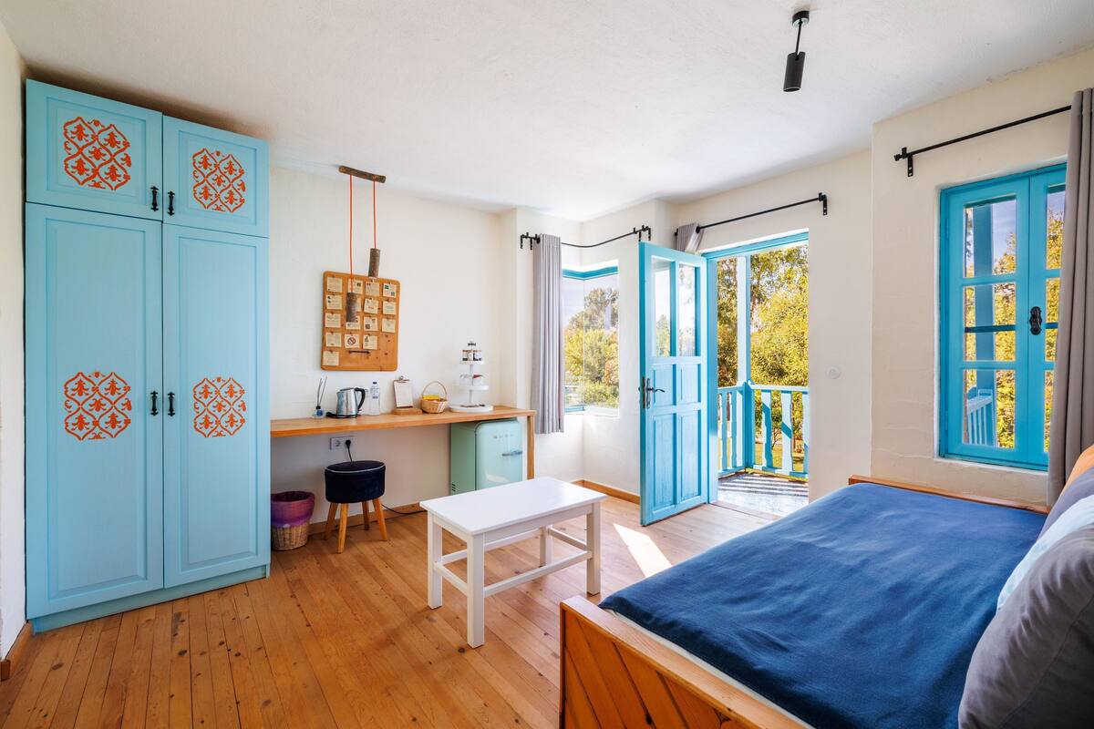 A room with a bed, a desk, a chair, and a wardrobe.