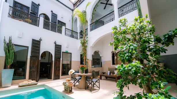 A courtyard with a pool, outdoor seating, and a staircase leading to upper floors. - Riad Dar Massai (Marrakech)