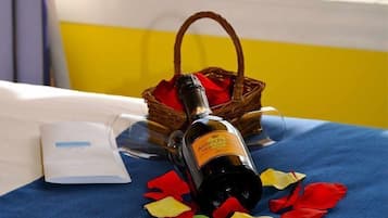 Una botella de vino sobre una mesa, con vistas a un lago a través de la barandilla de un balcón.