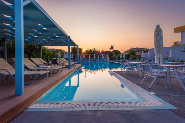 Una piscina al aire libre de temporada, sombrillas, tumbonas