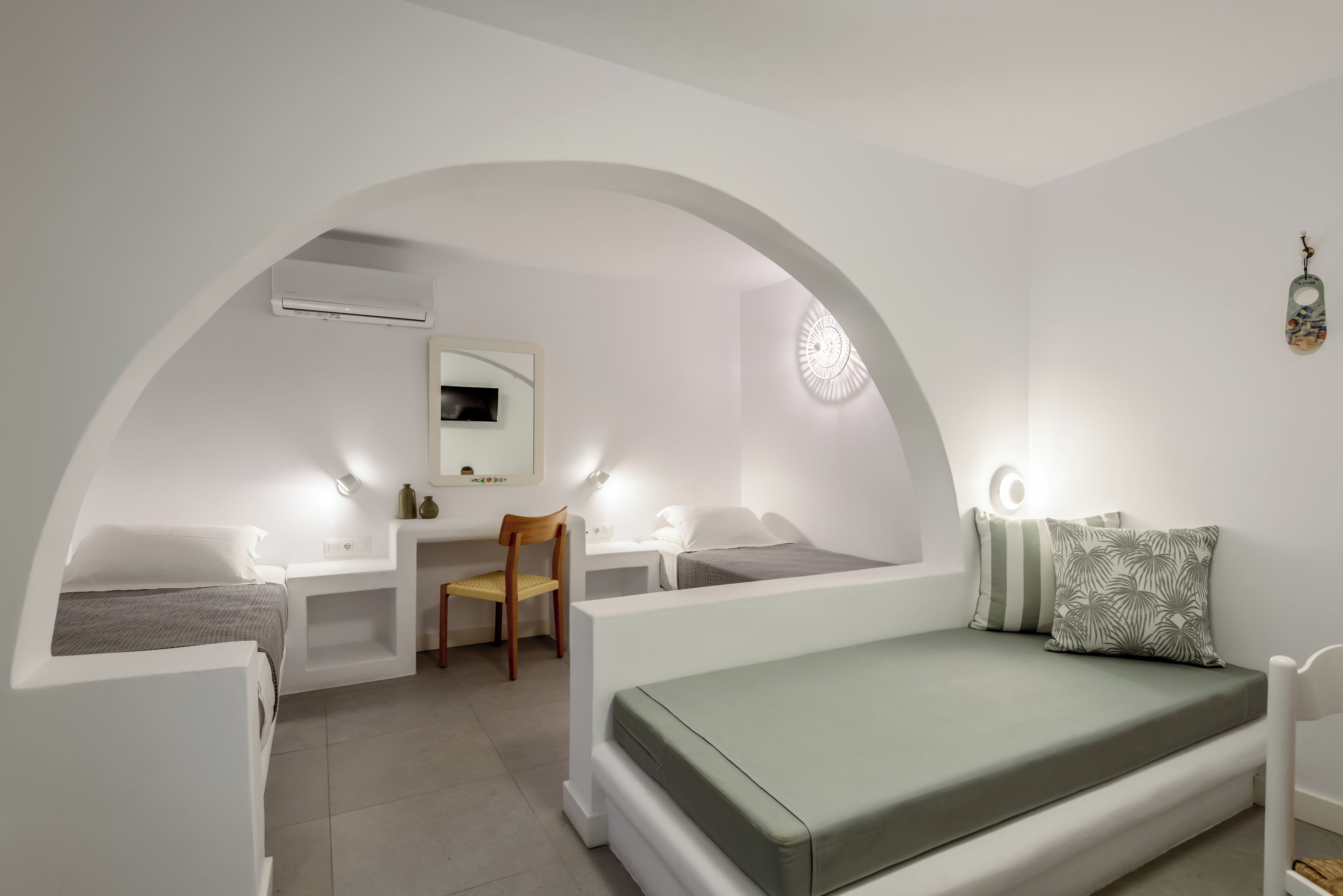 Een kleine kamer met een bed, bureau, stoel en een tafeltje.