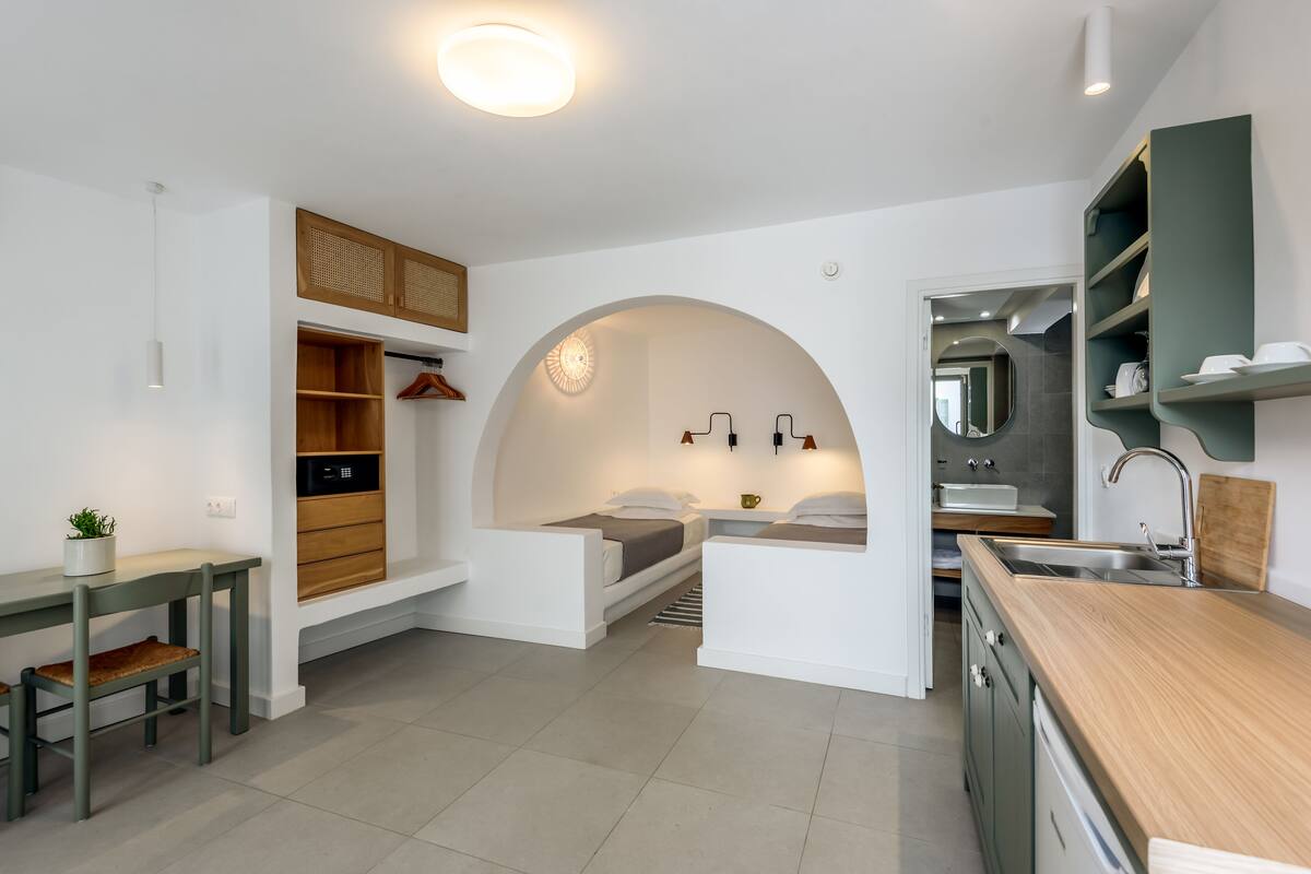 Een moderne keuken met een centraal eiland, inbouwkasten en een eethoek met een bank.