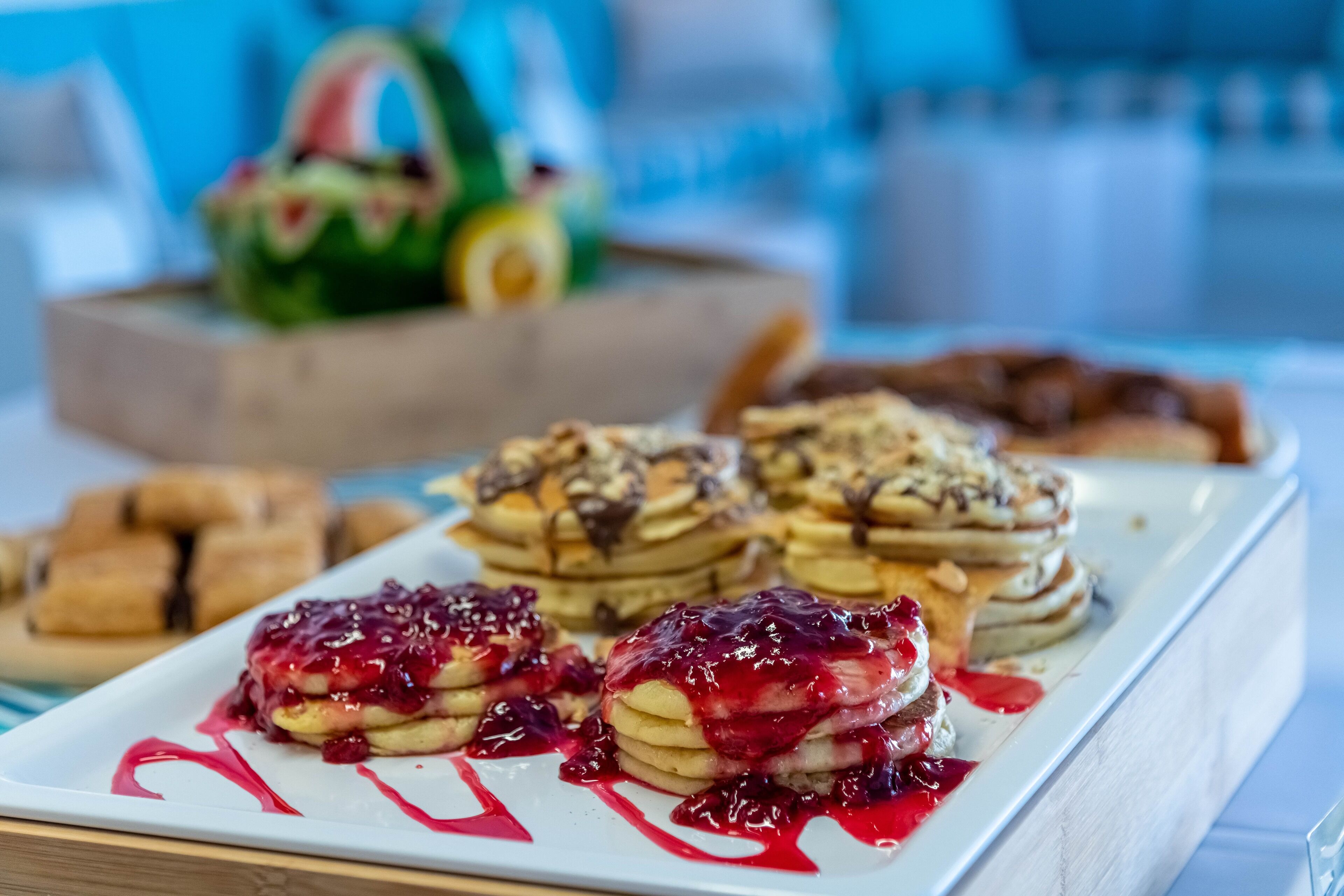 A breakfast buffet with pancakes, waffles, and pastries.