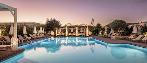 Una piscina al aire libre de temporada, sombrillas