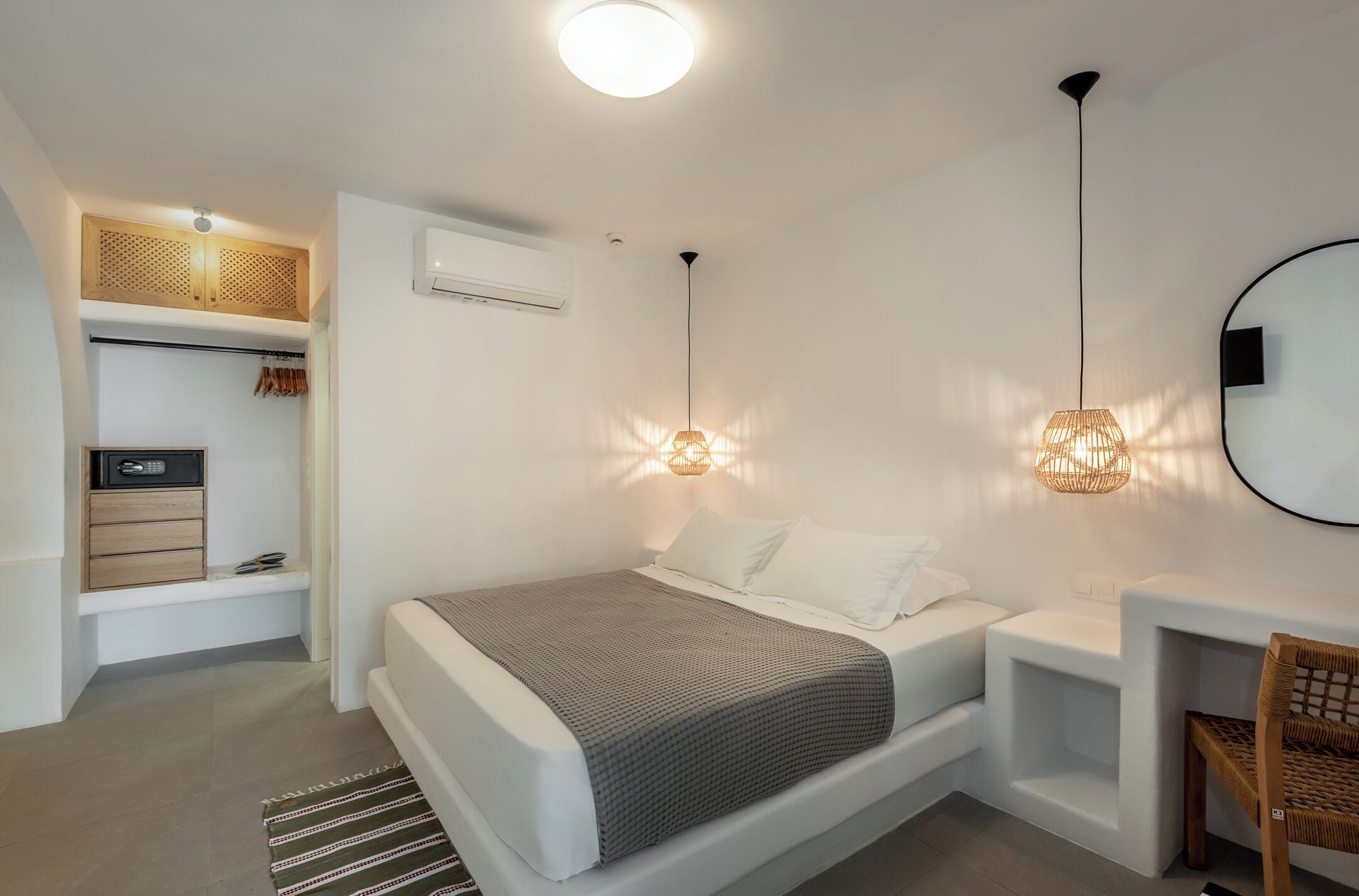 A modern bedroom with a bed, bedside tables, a wardrobe, and a mirror.