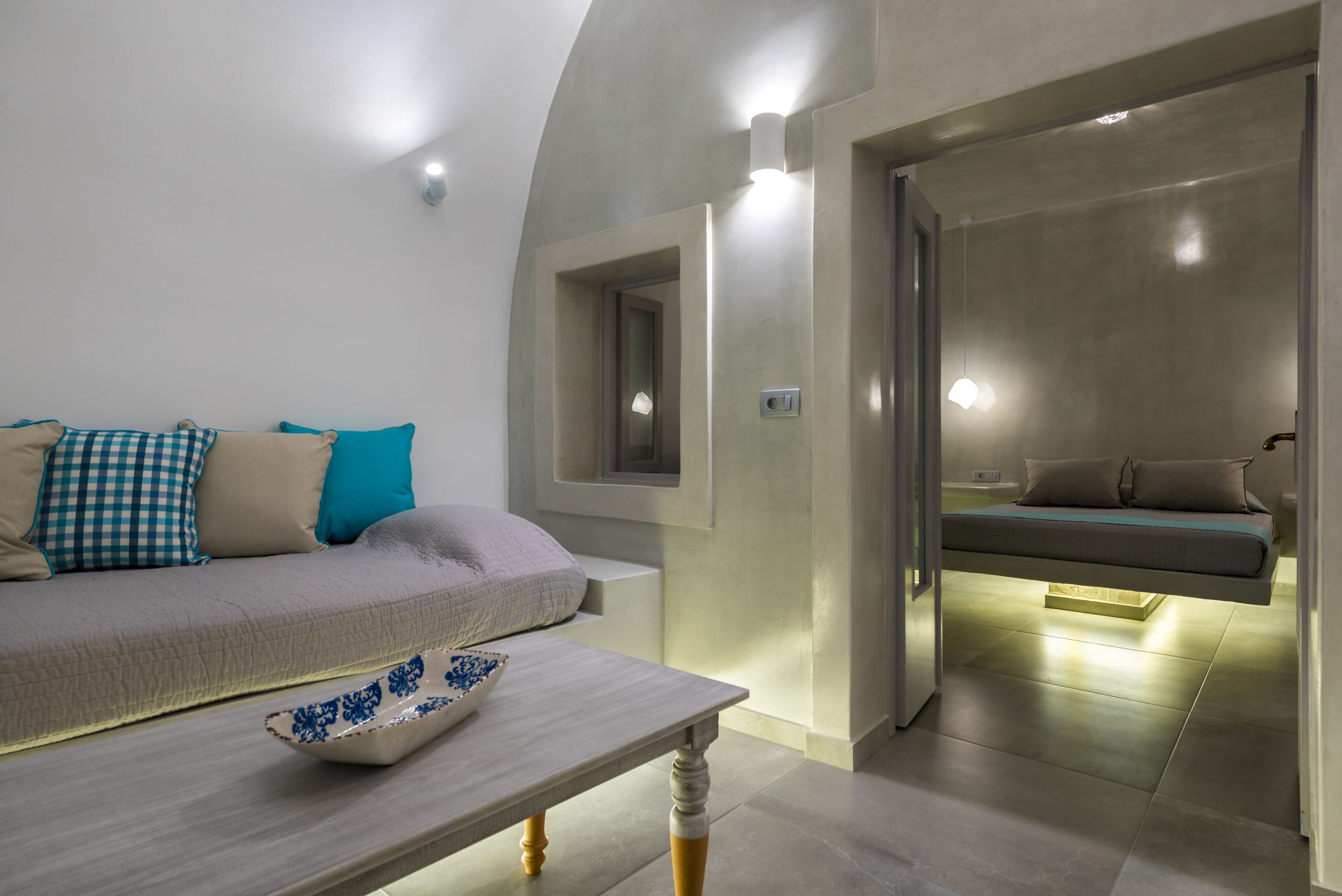 Une chambre moderne avec un canapé, une table et un lit suspendu.