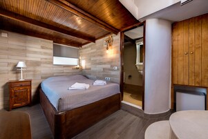 Un dormitorio con una cama de madera, un mesita de noche, un tocador, un espejo y un vestidor.