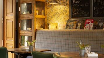 Interior acogedor de un restaurante con armarios de madera, un banco a cuadros y un menú en la pizarra.