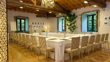 Un amplio comedor con una larga mesa dispuesta para un banquete, rodeada de sillas.