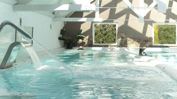 Swim laps in the calm pool surrounded by a brick wall and a window offering a view of lush greenery.