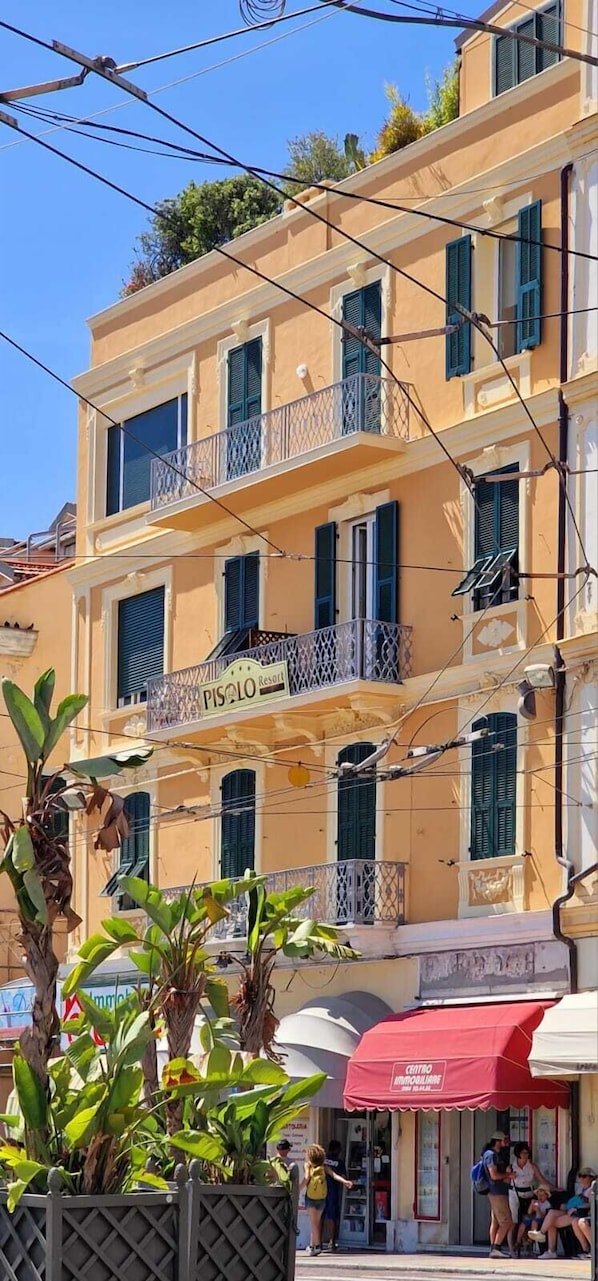 Un edificio de varios pisos con balcones, una señal que indica