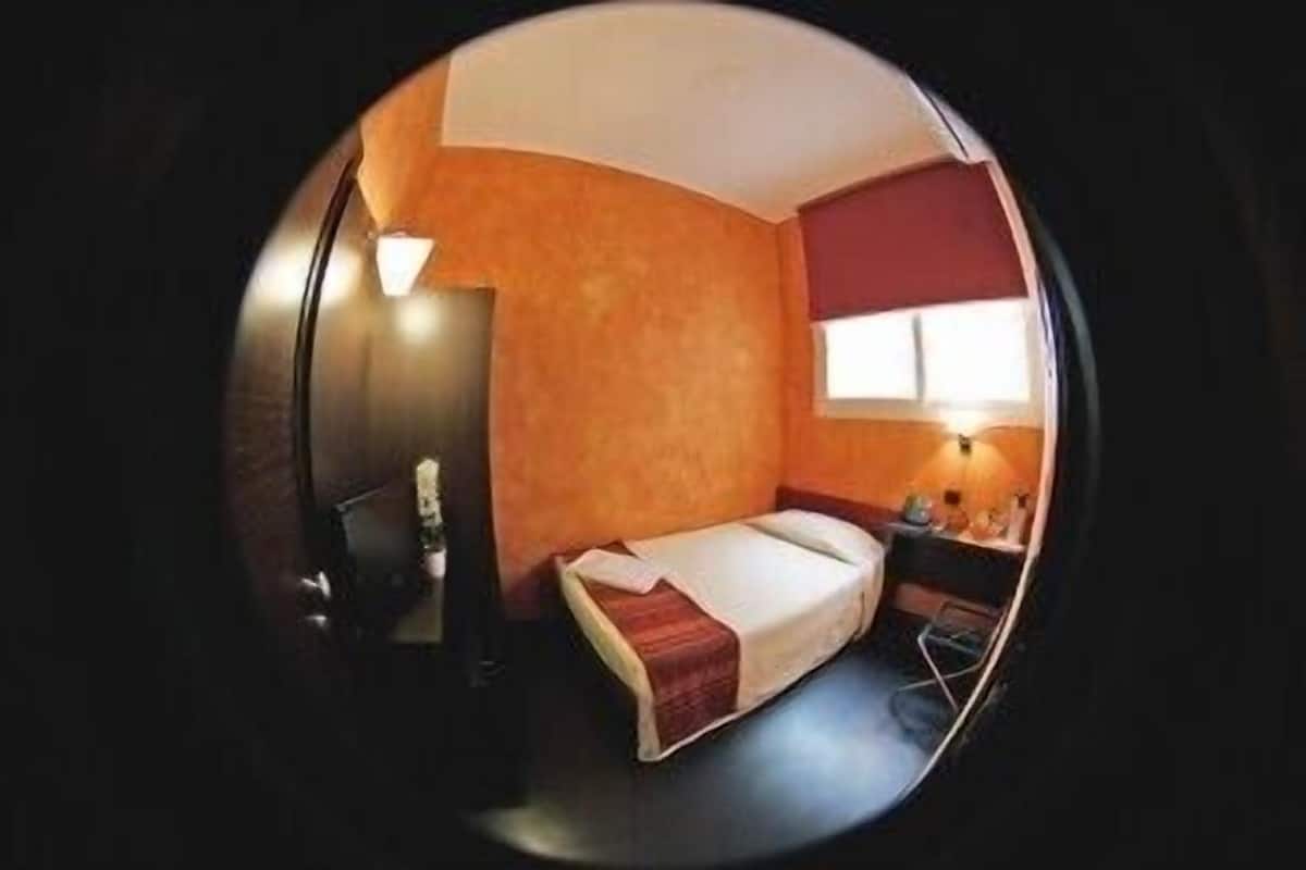 A compact room with a bed, a desk, and a chair.