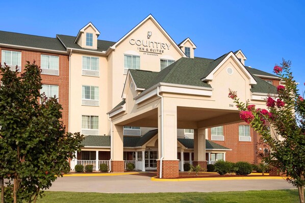 A Country Inn & Suites building with a prominent entrance, multiple windows, and a brick facade.