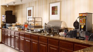 A buffet setup with a coffee machine, a waffle maker, and various food items on a counter. - Country Inn & Suites by Radisson, Conway, AR (Conway)