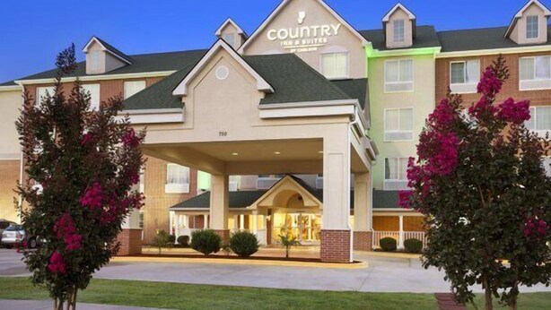 A Country Inn & Suites hotel with a covered entrance, multiple floors, and a well-maintained lawn. - Country Inn & Suites by Radisson, Conway, AR (Conway)