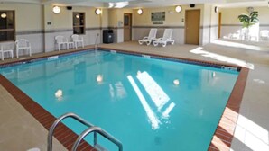 An indoor swimming pool with a clear water surface, a metal ladder, and white lounge chairs around the perimeter. - Country Inn & Suites by Radisson, Conway, AR (Conway)