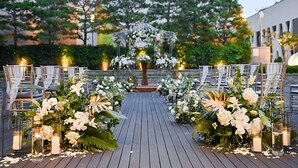 An outdoor wedding aisle with floral arrangements and candles.