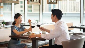 A couple dining at a table with a view of a cityscape.
