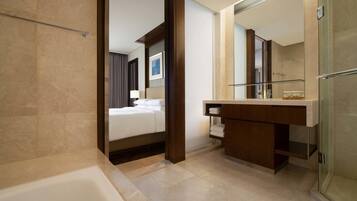 A modern bathroom with a bathtub, a vanity with a mirror, and a shower area.