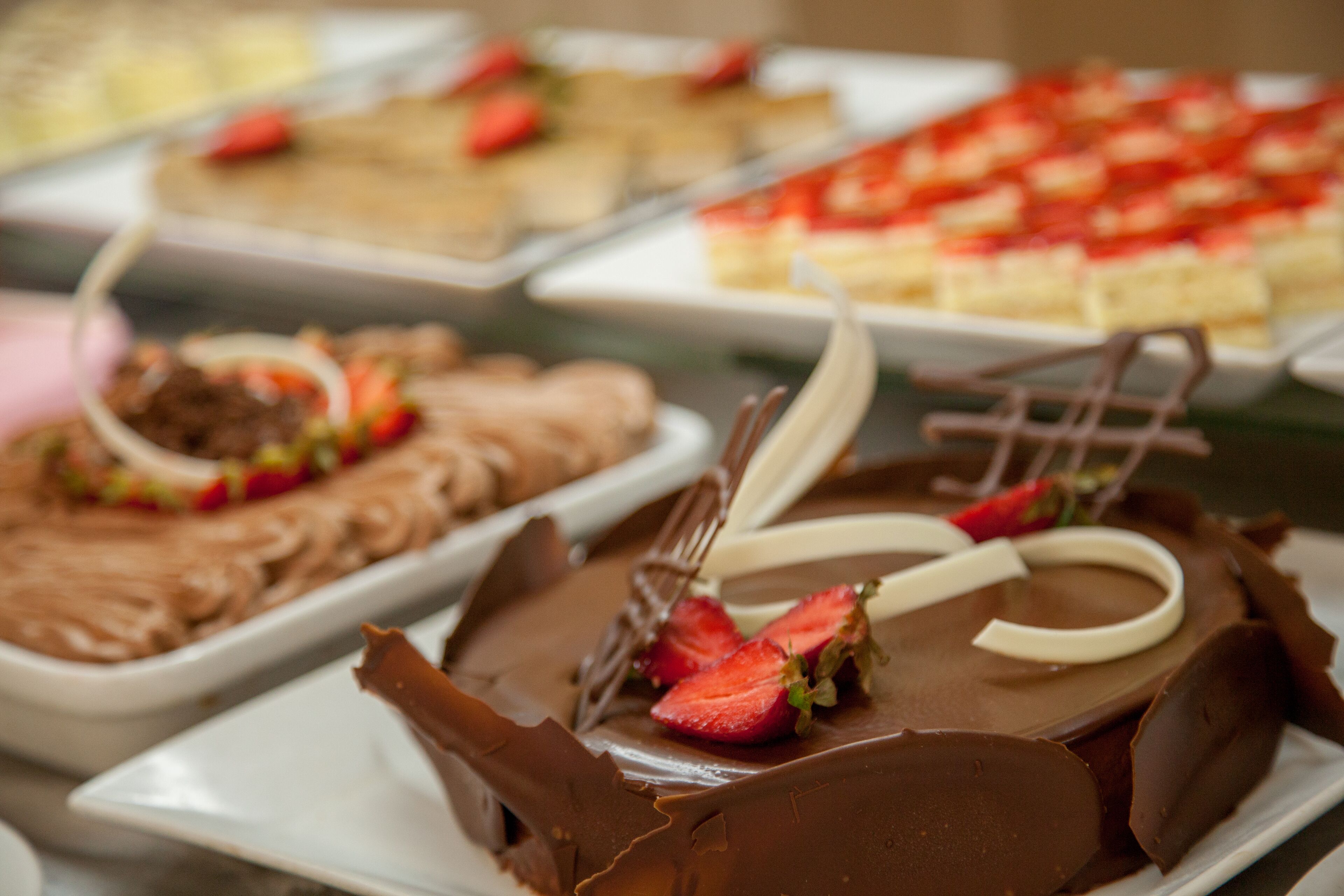 A variety of desserts on display, including chocolate-covered cakes and pastries.