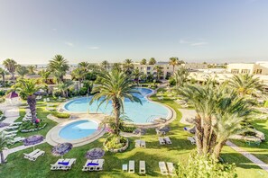 Una piscina cubierta, una piscina al aire libre de temporada, sombrillas