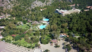 An aerial view of a resort with multiple swimming pools, a large hotel building, and surrounding lush greenery. - TUI MAGIC LIFE Sarigerme - All Inclusive (Ortaca)