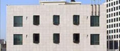Un edificio de varios pisos con una hilera de ventanas y un letrero que dice "The Grand Hotel".