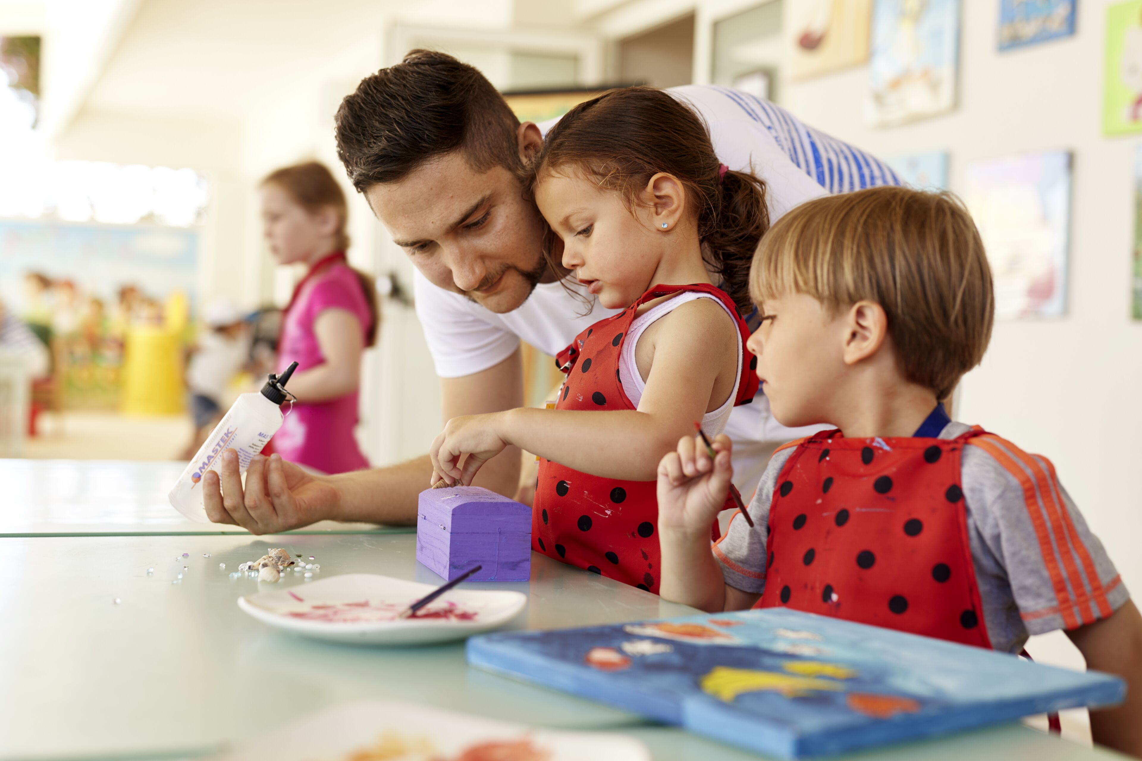 A family painting a purple block.