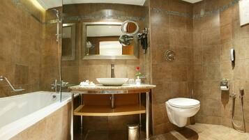 Ein Badezimmer mit Badewanne, Waschbecken, Toilette und Duschbereich.
