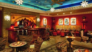 Zona de bar con pared de ladrillo, varias opciones de asientos e iluminación decorativa.