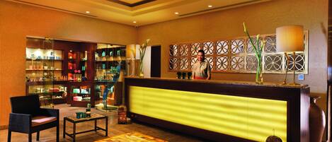 A hotel reception area with a reception desk, seating area, and a display of toiletries.