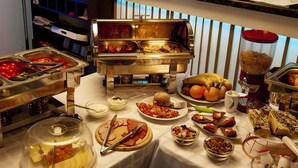 A buffet table with various food items and utensils. - Weekend Boutique Hotel (Chisinau)
