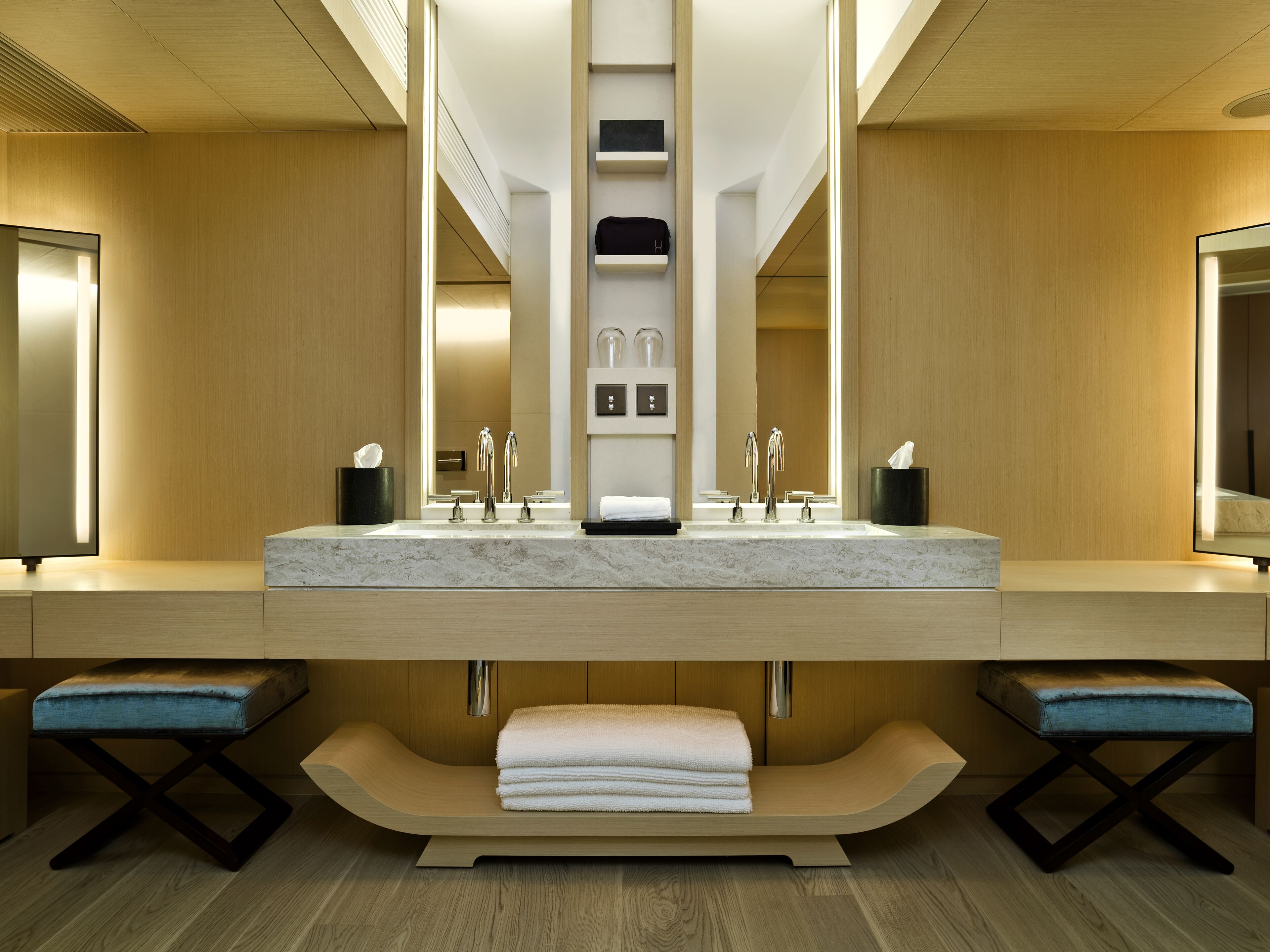 A modern bathroom with a large mirror, dual sinks, and a towel rack.