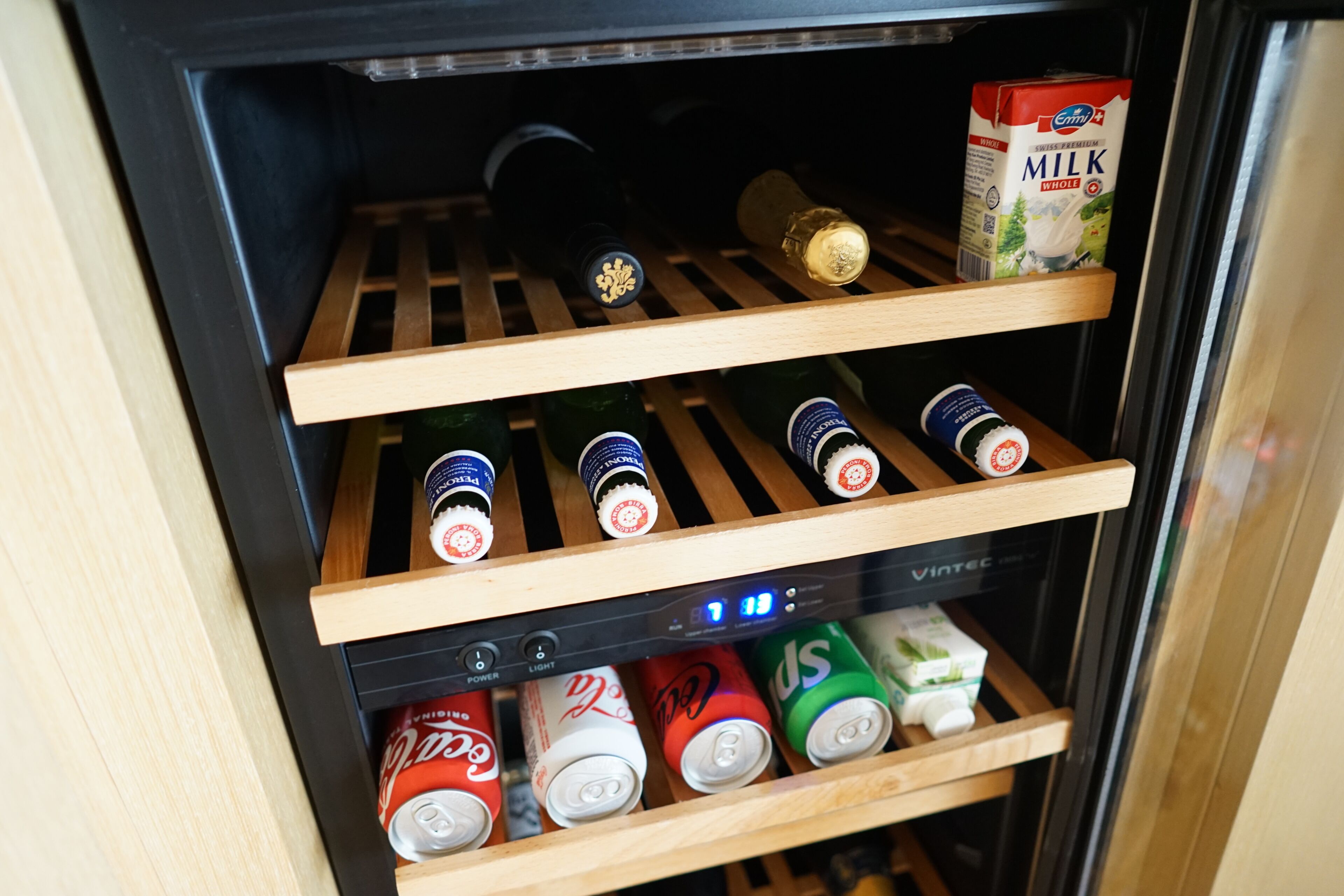 Ein Getränkekühlschrank mit Regalen für Flaschen und Dosen.