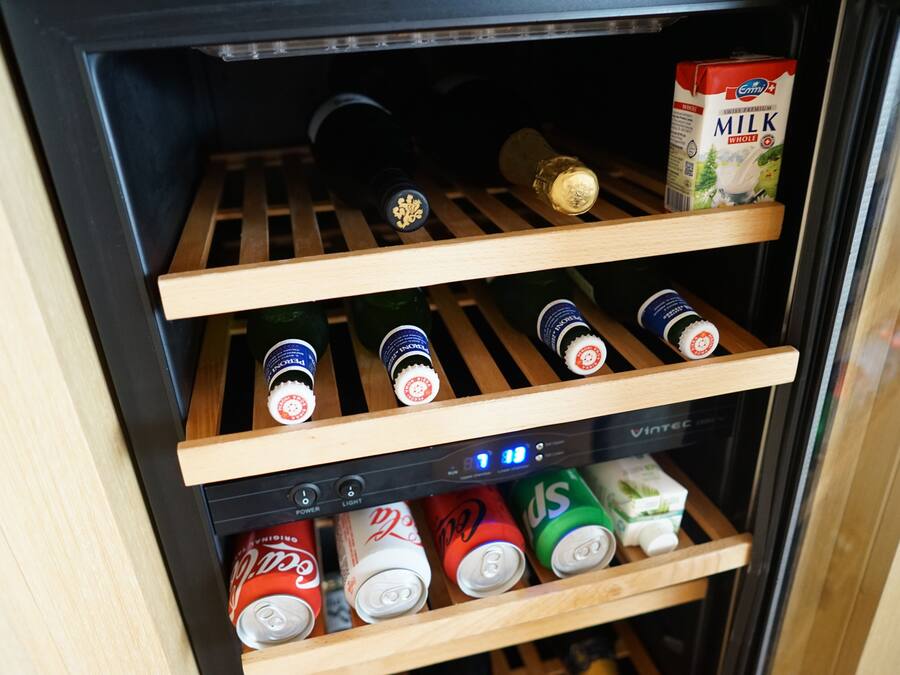Ein Getränkekühlschrank mit Regalen für Flaschen und Dosen.