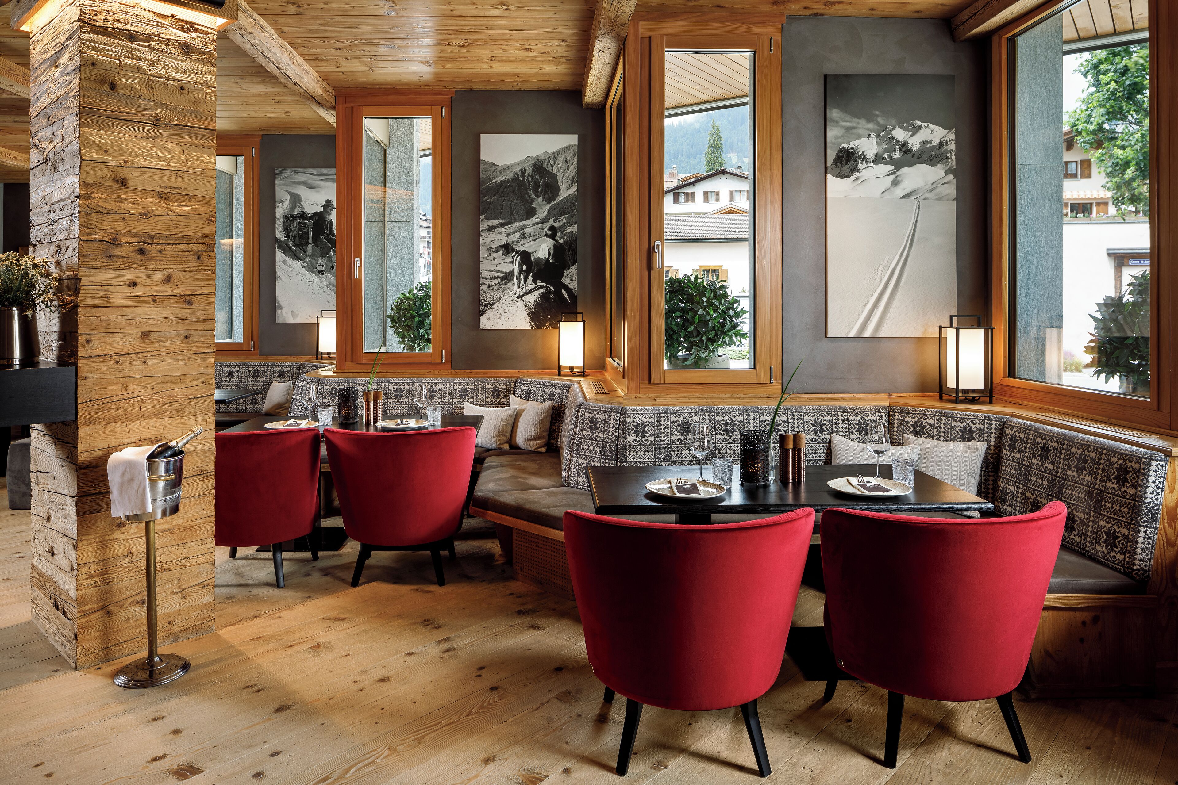 Een restaurant met houten wanden, rode stoelen en een houten vloer.